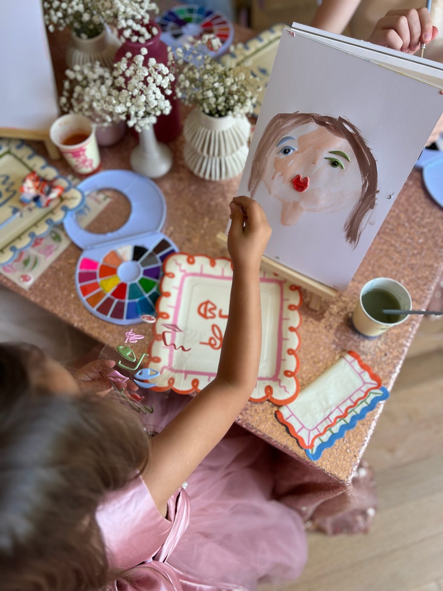 Child painting with Art Party Paper Pad using watercolor paints at a creative art party table