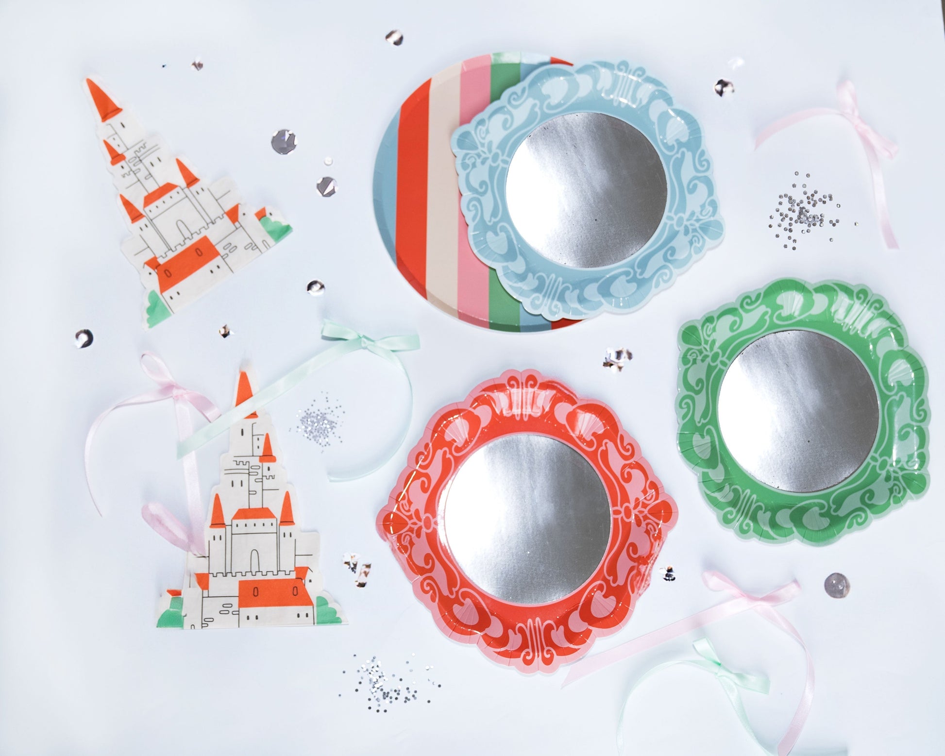 Mirror Mirror princess party dessert plates with reflective centers and ornate colored frames, set on a table with castle decorations and ribbons.