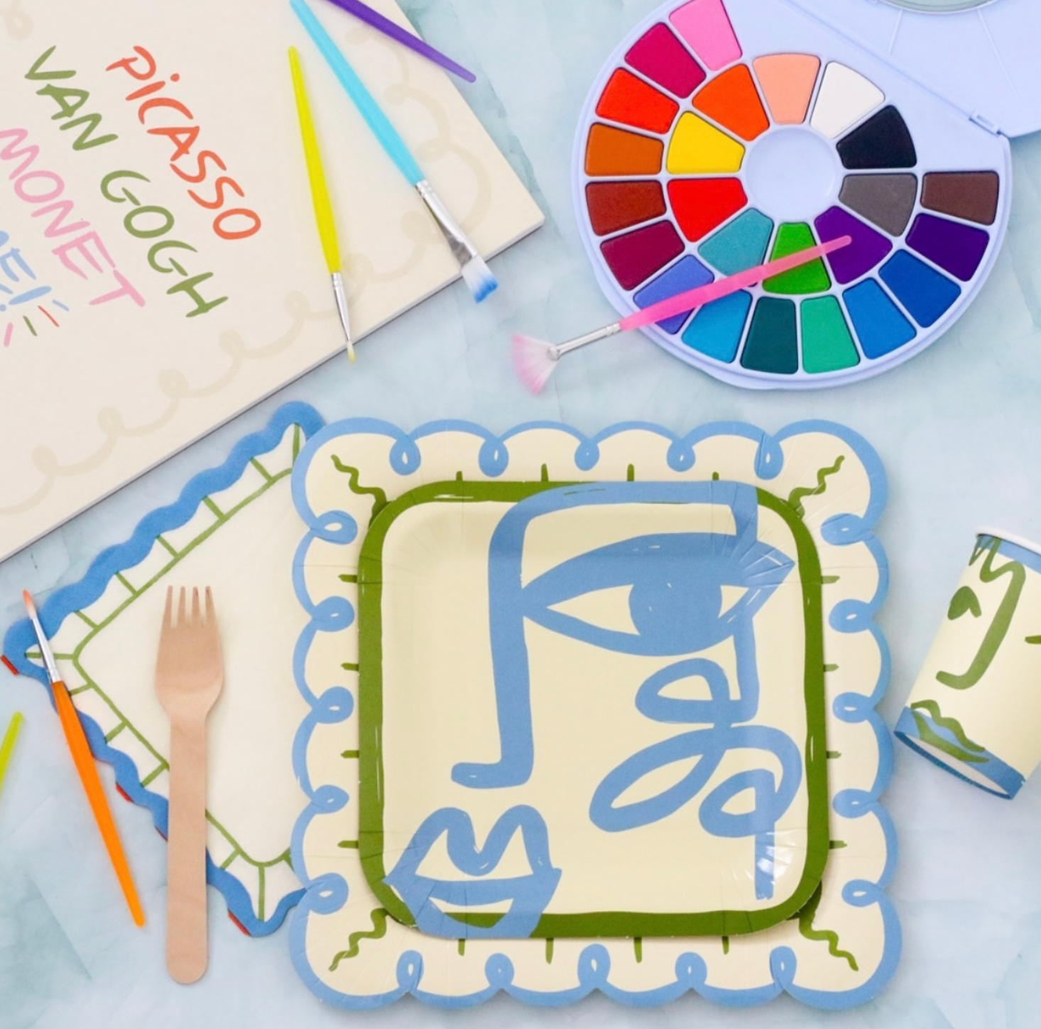 Artistic table setting with Picasso and Van Gogh inspired paper pad, watercolor set.
