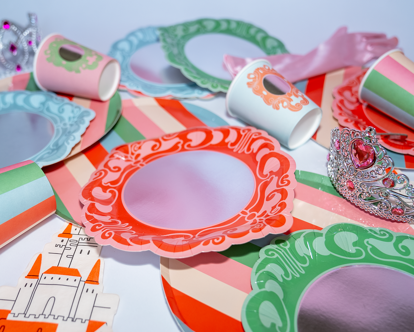 Mirror Mirror princess party dessert plates with reflective surface and colorful decorative borders arranged with matching cups and party accessories