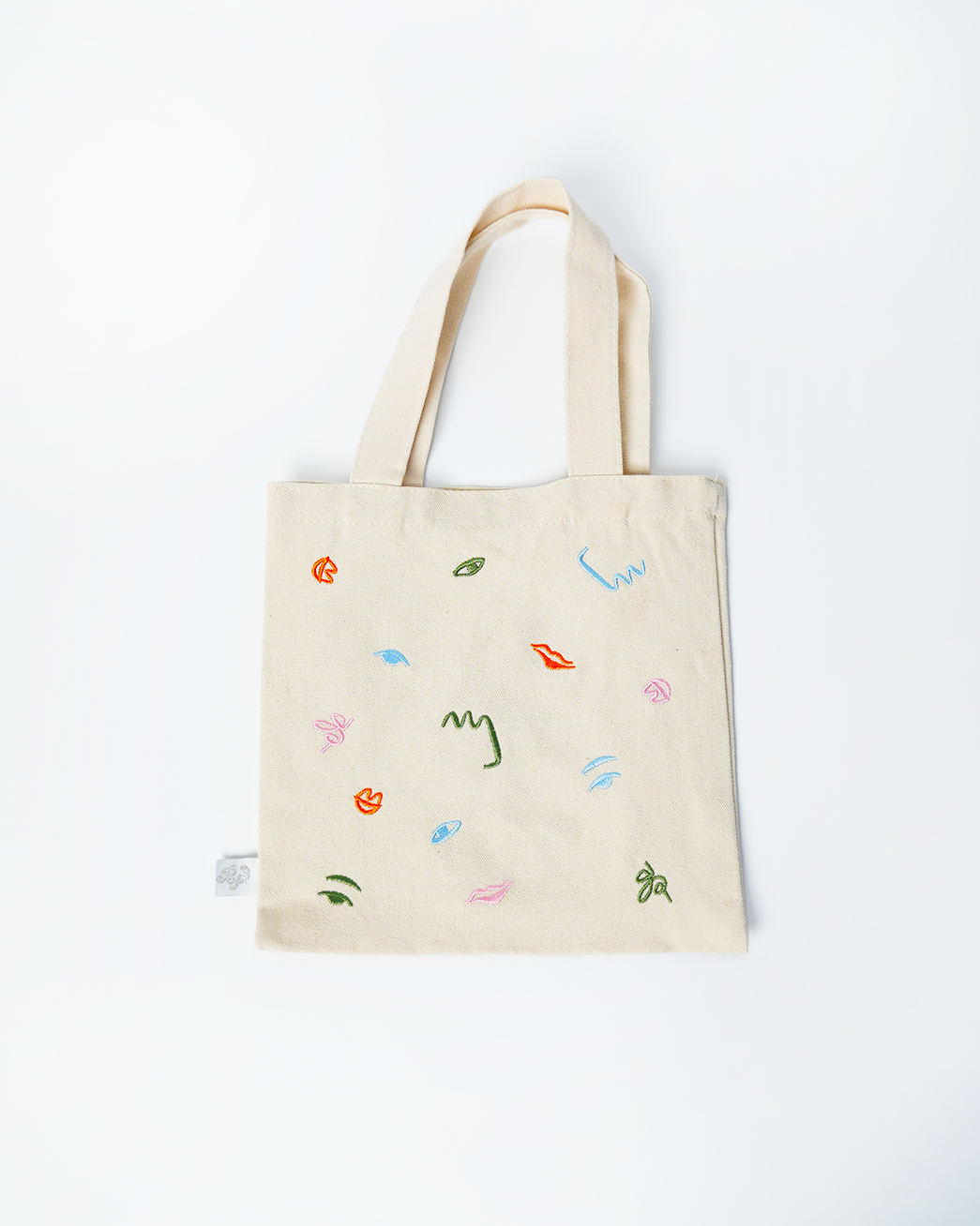 Mini tote bag with colorful abstract embroidery, kid-sized and reusable for art party theme events.