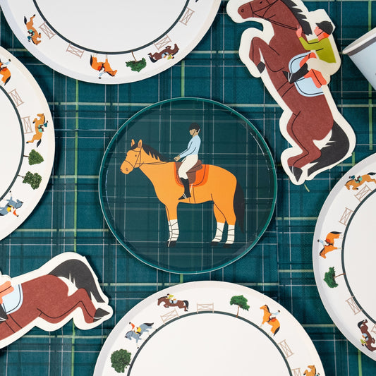 Horse party supplies set with dinner plates, dessert plates, cups, and napkins featuring horse and rider designs on plaid background